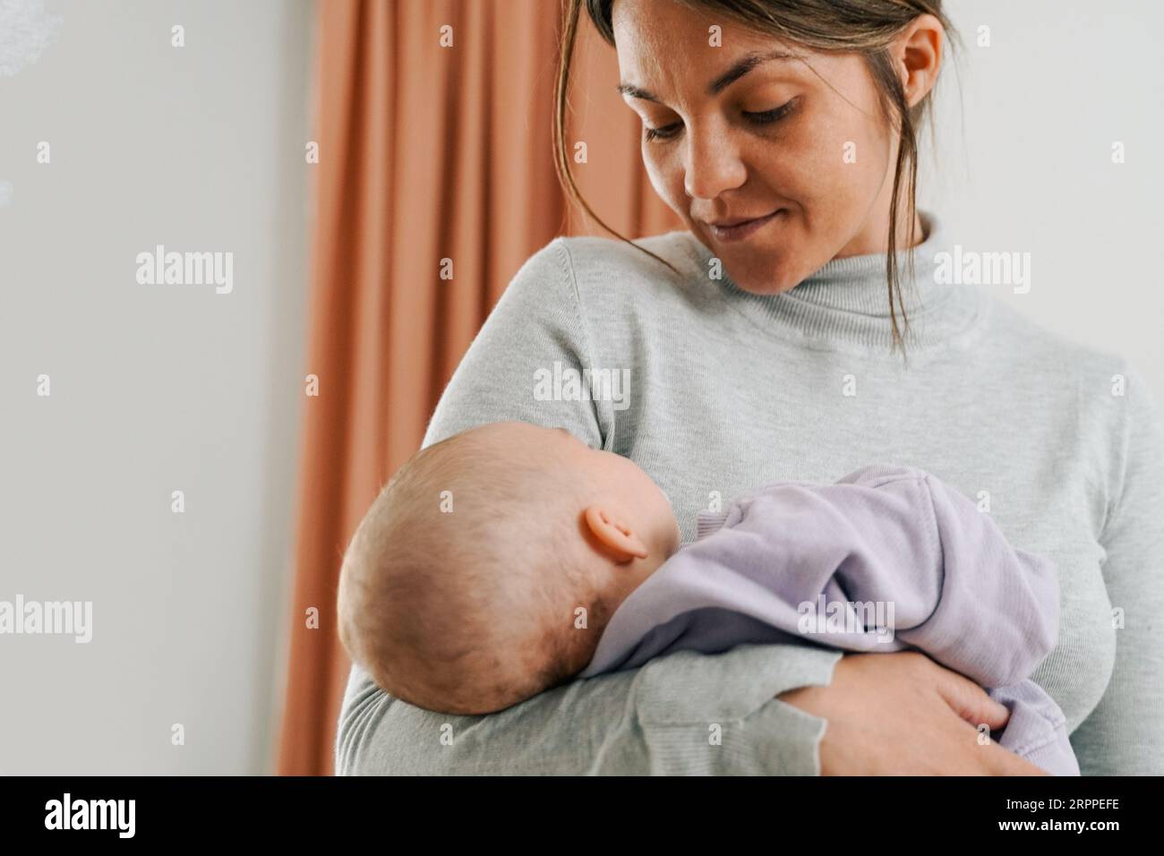 Newborn baby and latin mother hold infant son at home - Family mum and child relationship Stock Photo