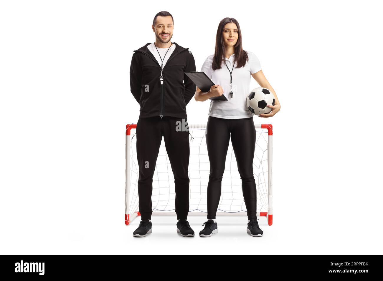 Full length portrait of a male and female football coaches posing in front of mini goal isolated on white background Stock Photo