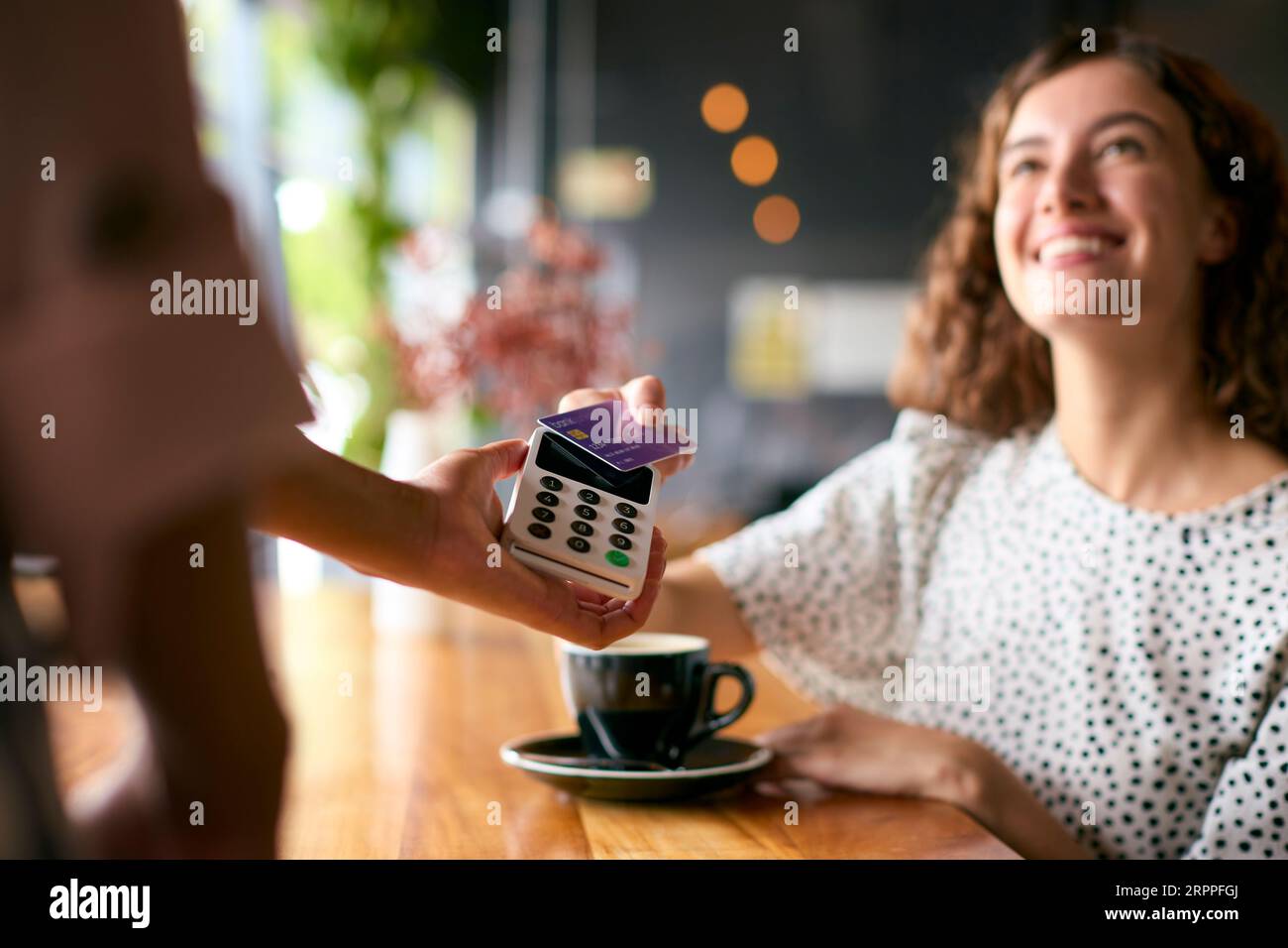 Woman In Coffee Shop Paying Bill With Contactless Card Payment Stock ...