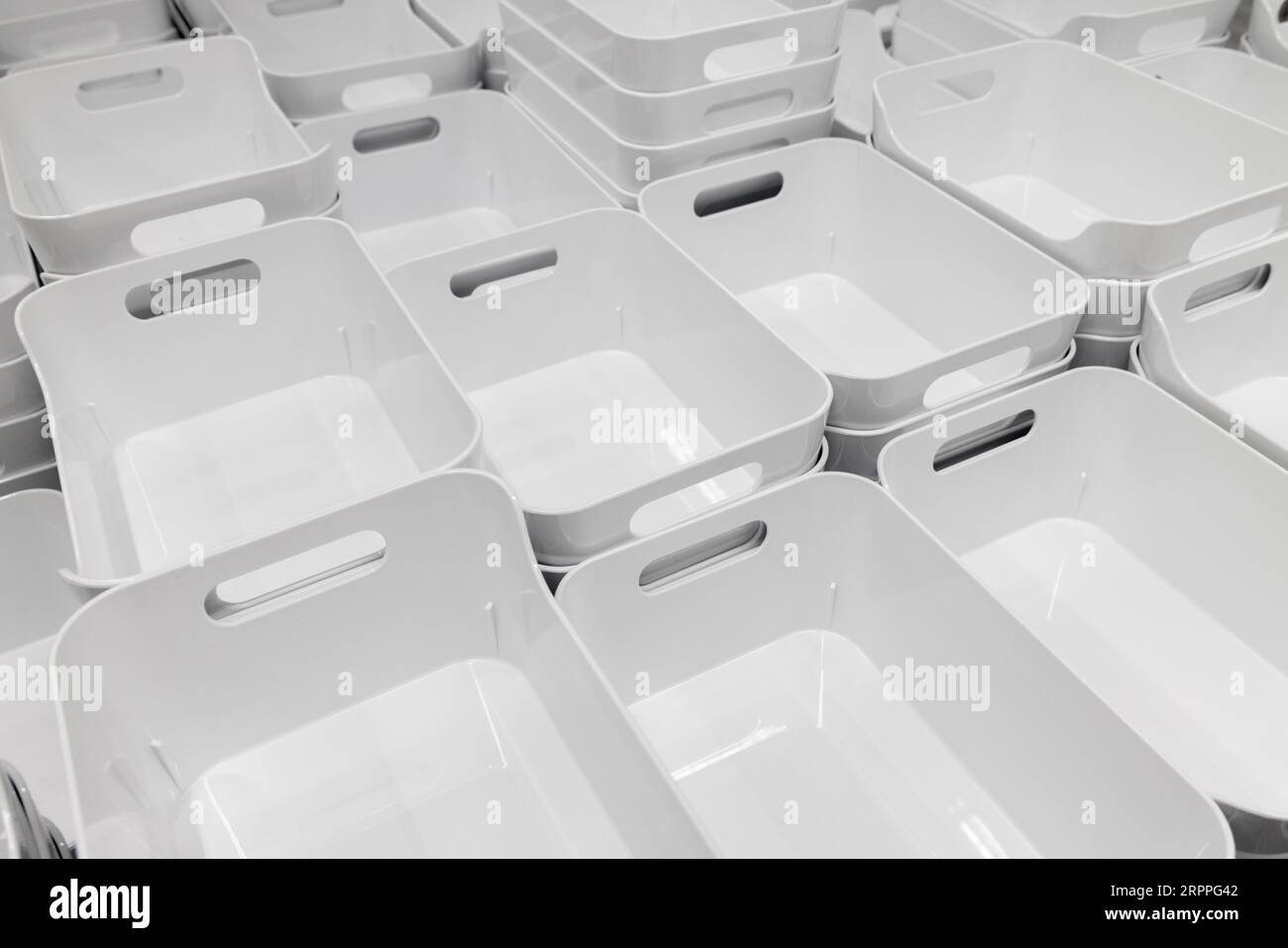 White plastic baskets neatly stacked in rows in the showroom section of the IKEA home store Stock Photo