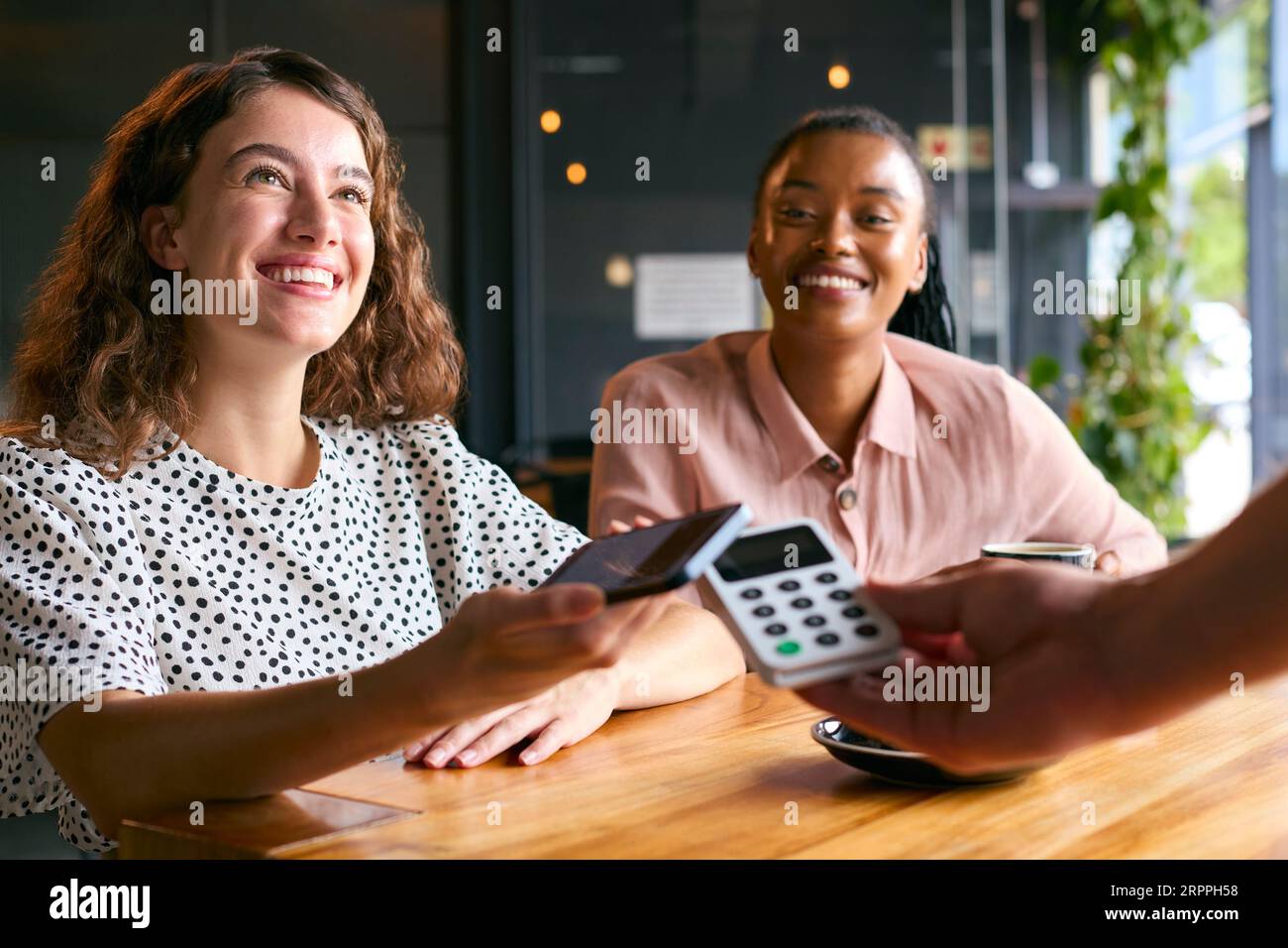 Two women coffee shop bill hi-res stock photography and images - Alamy