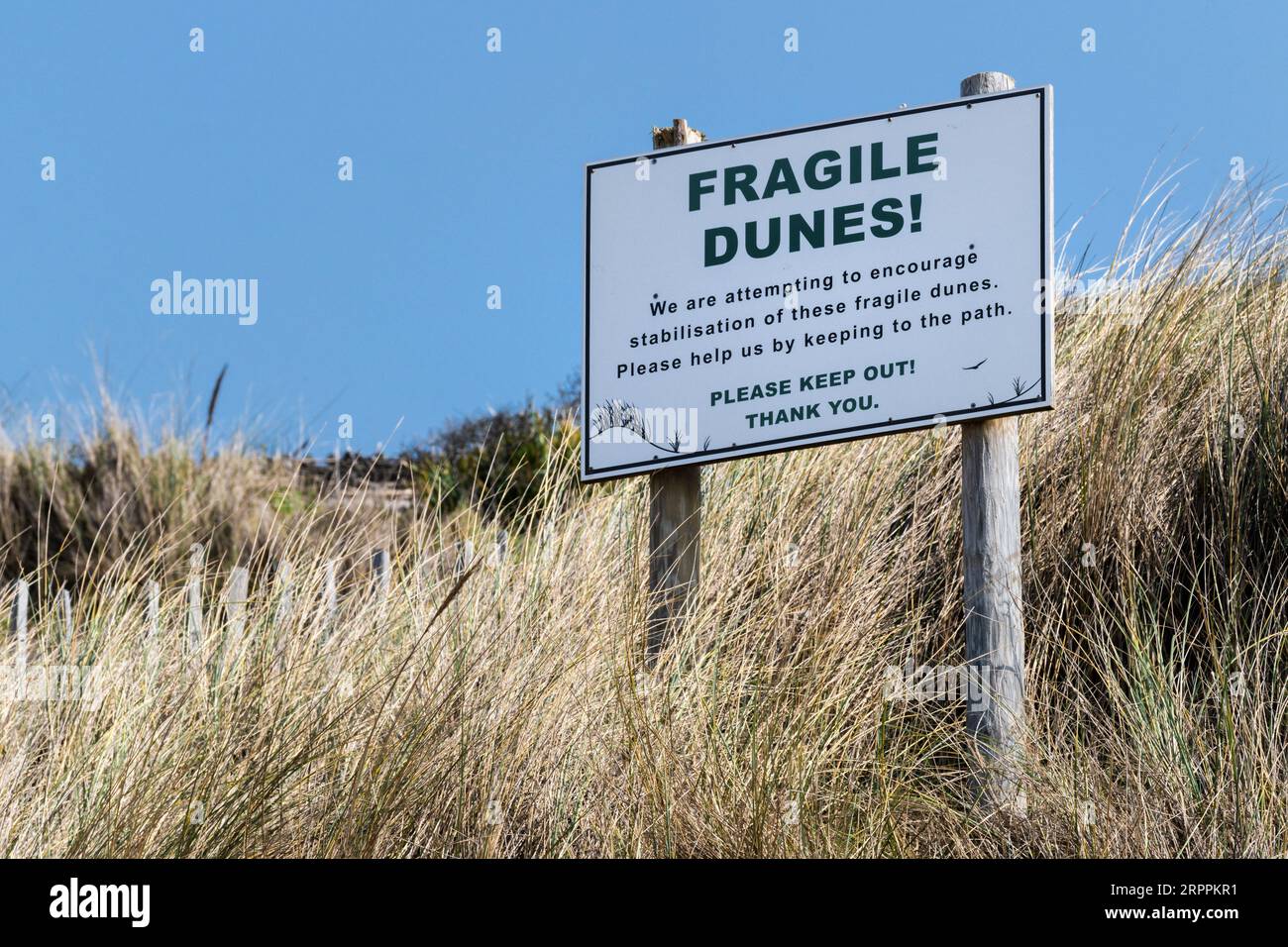 A sign warning of fragile dunes at Mawgan Porth in Cornwall in the UK. Stock Photo