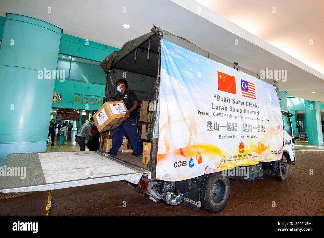 200320 -- BEIJING, March 20, 2020 -- A worker unloads boxes containing medical supplies during a handover ceremony at Sungai Buloh hospital in Sungai Buloh, Selangor, Malaysia, March 19, 2020. The Chinese embassy and Chinese companies in Malaysia on Thursday donated the first batch of medical supplies to Malaysian hospitals to fight the COVID-19 spread. The medical materials, including 5,000 face masks and 10,000 surgical masks, were delivered to Malaysia s Sungai Buloh hospital, one of the designated facilities to treat COVID-19 patients.  XINHUA PHOTOS OF THE DAY ZhuxWei PUBLICATIONxNOTxINxC Stock Photo