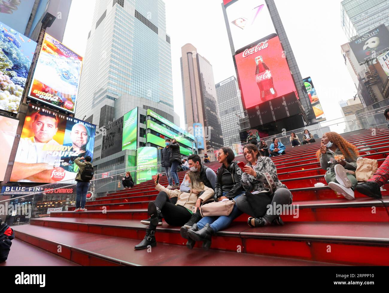 200320 -- NEW YORK, March 20, 2020 -- Tourists wearing facial masks sit on the red stairs on Times Square in New York City, the United States, March 19, 2020. The number of COVID-19 cases in the United States topped 13,000 as of 5:30 p.m. 2130 GMT on Thursday, according to the Center for Systems Science and Engineering CSSE at Johns Hopkins University. The fresh figure reached 13,060 with 175 deaths.  U.S.-COVID-19 CASES WangxYing PUBLICATIONxNOTxINxCHN Stock Photo