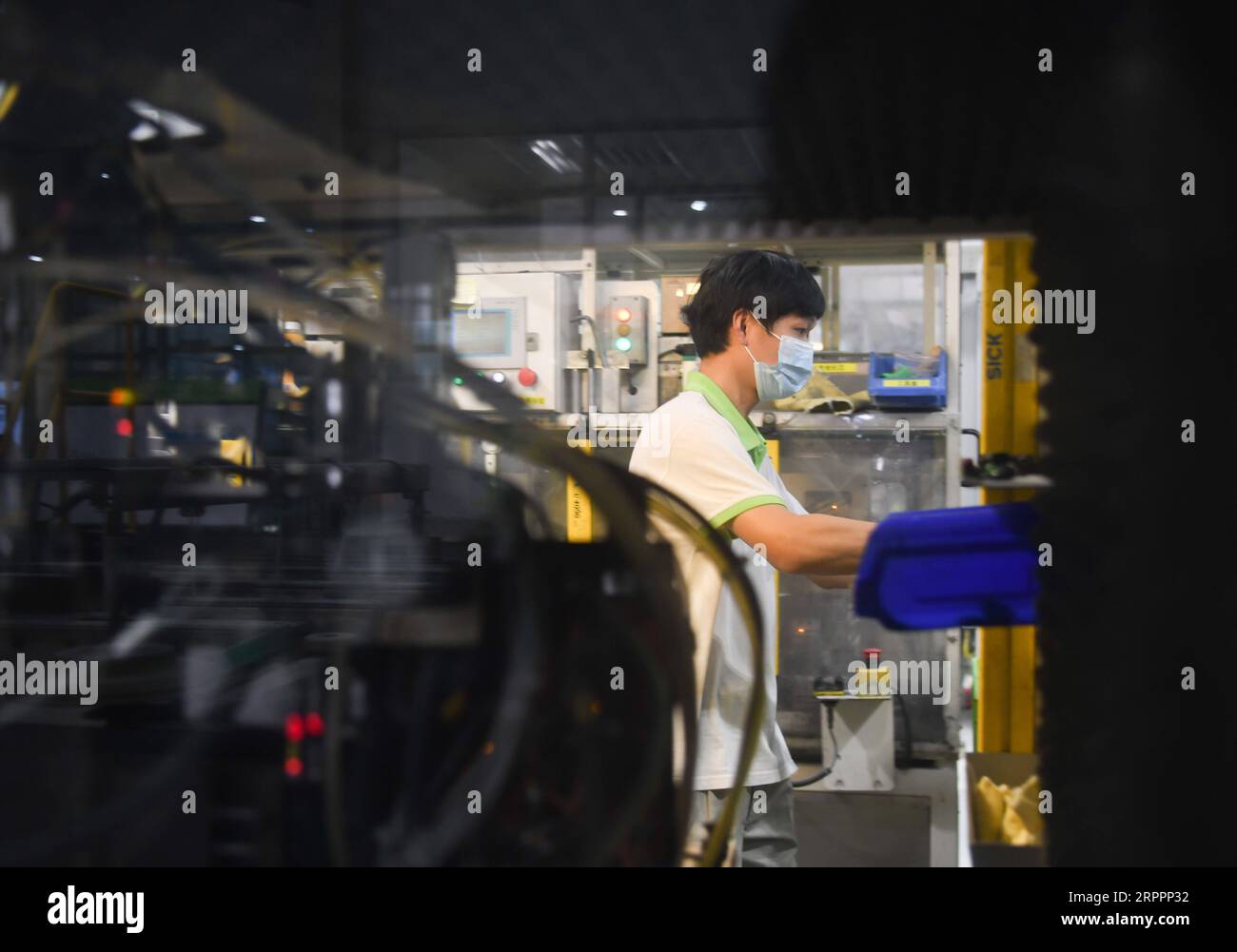 200320 -- WUHAN, March 20, 2020 -- A staff member works on a production line at a company in Jingzhou, central China s Hubei Province, March 19, 2020. The Valeo Hubei company has resumed production since late February. Over 90% capacity of the company has recovered and over 80% staff members have returned to their work.  CHINA-HUBEI-JINGZHOU-PRODUCTION RESUMPTION CN ChengxMin PUBLICATIONxNOTxINxCHN Stock Photo