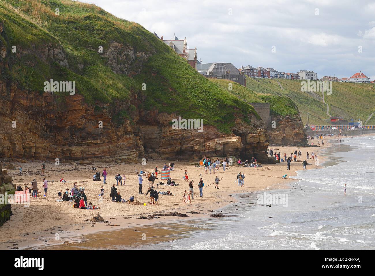 Tourists enjoying time on the beach on a summers day in Whitby,North Yorkshire,UK Stock Photo
