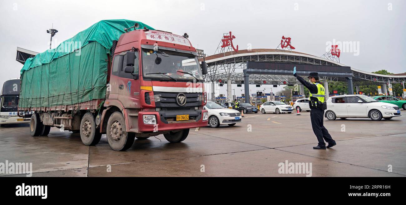 200324 -- WUHAN, March 24, 2020 -- A policeman on duty prepares to check a truck at a highway toll station in Wuhan, central China s Hubei Province, March 24, 2020. Wuhan, the Chinese city hardest hit by the novel coronavirus outbreak, will lift outbound travel restrictions from April 8 after over two months of lockdown, local authorities said Tuesday. People in Wuhan will be allowed to leave the city and Hubei Province, where Wuhan is the capital, if they hold a green health code, meaning no contact with any infected or suspected COVID-19 cases, according to a circular issued by the provincia Stock Photo