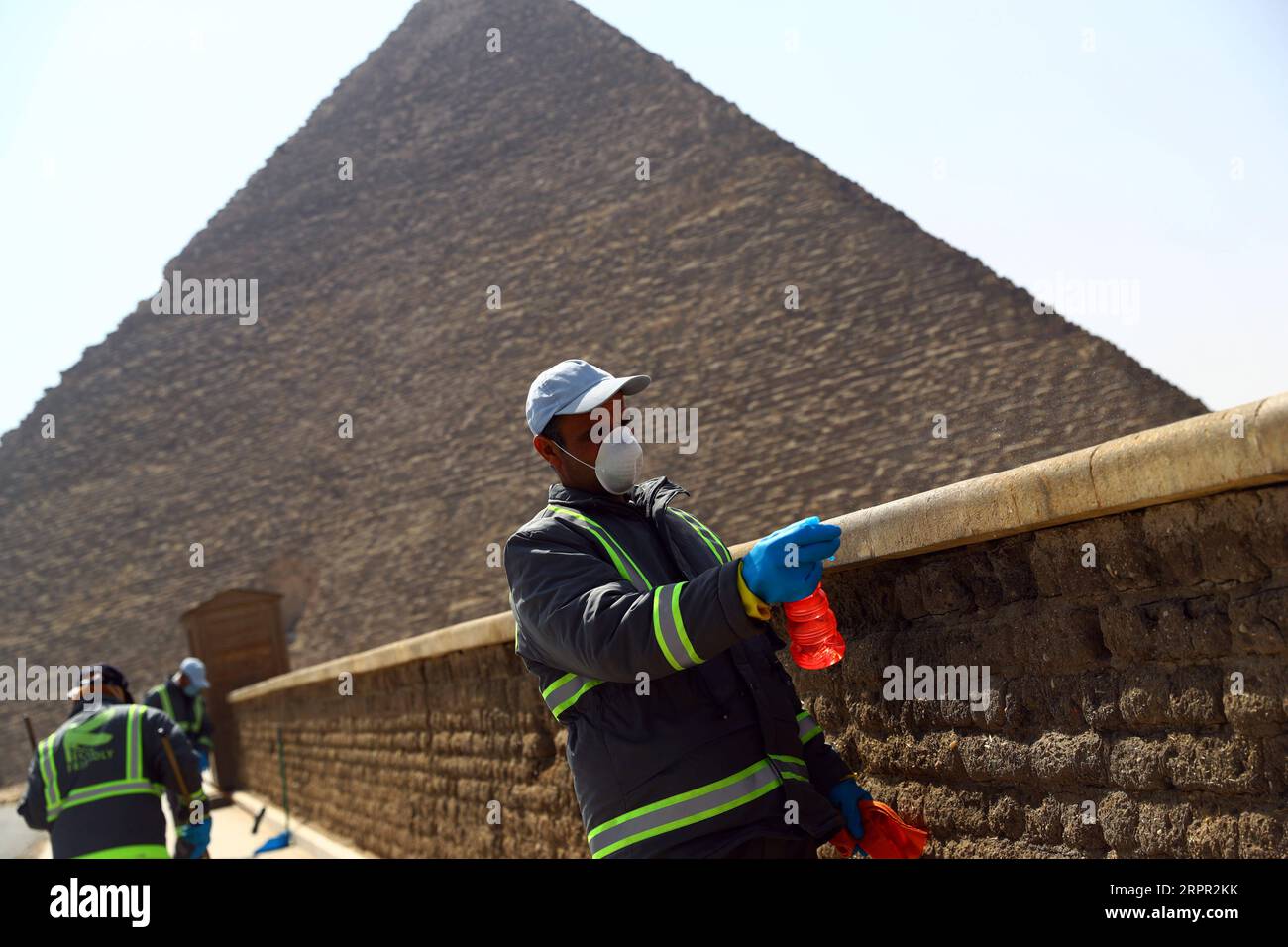 200325 -- GIZA, March 25, 2020 Xinhua -- A staff member disinfects near the Pyramids in Giza, Egypt, March 25, 2020. Egypt announced on Tuesday that one COVID-19 case died and 36 new cases were detected, bringing the total number of cases in the country to 402. Xinhua/Ahmed Gomaa EGYPT-GIZA-PYRAMIDS-DISINFECTION PUBLICATIONxNOTxINxCHN Stock Photo