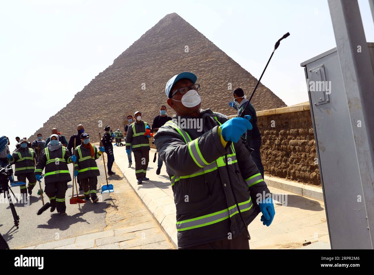200325 -- GIZA, March 25, 2020 Xinhua -- A staff member disinfects near the Pyramids in Giza, Egypt, March 25, 2020. Egypt announced on Tuesday that one COVID-19 case died and 36 new cases were detected, bringing the total number of cases in the country to 402. Xinhua/Ahmed Gomaa EGYPT-GIZA-PYRAMIDS-DISINFECTION PUBLICATIONxNOTxINxCHN Stock Photo