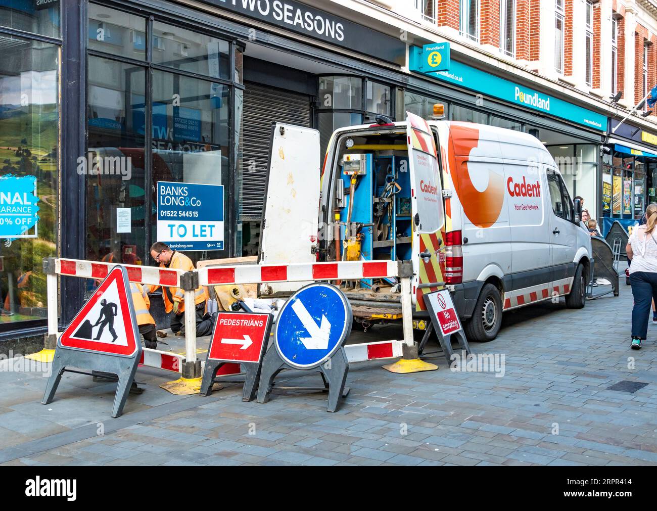 Cadent gas engineers working on gas pipe to empty shop, High street, Lincoln City, Lincolnshire, England, UK Stock Photo