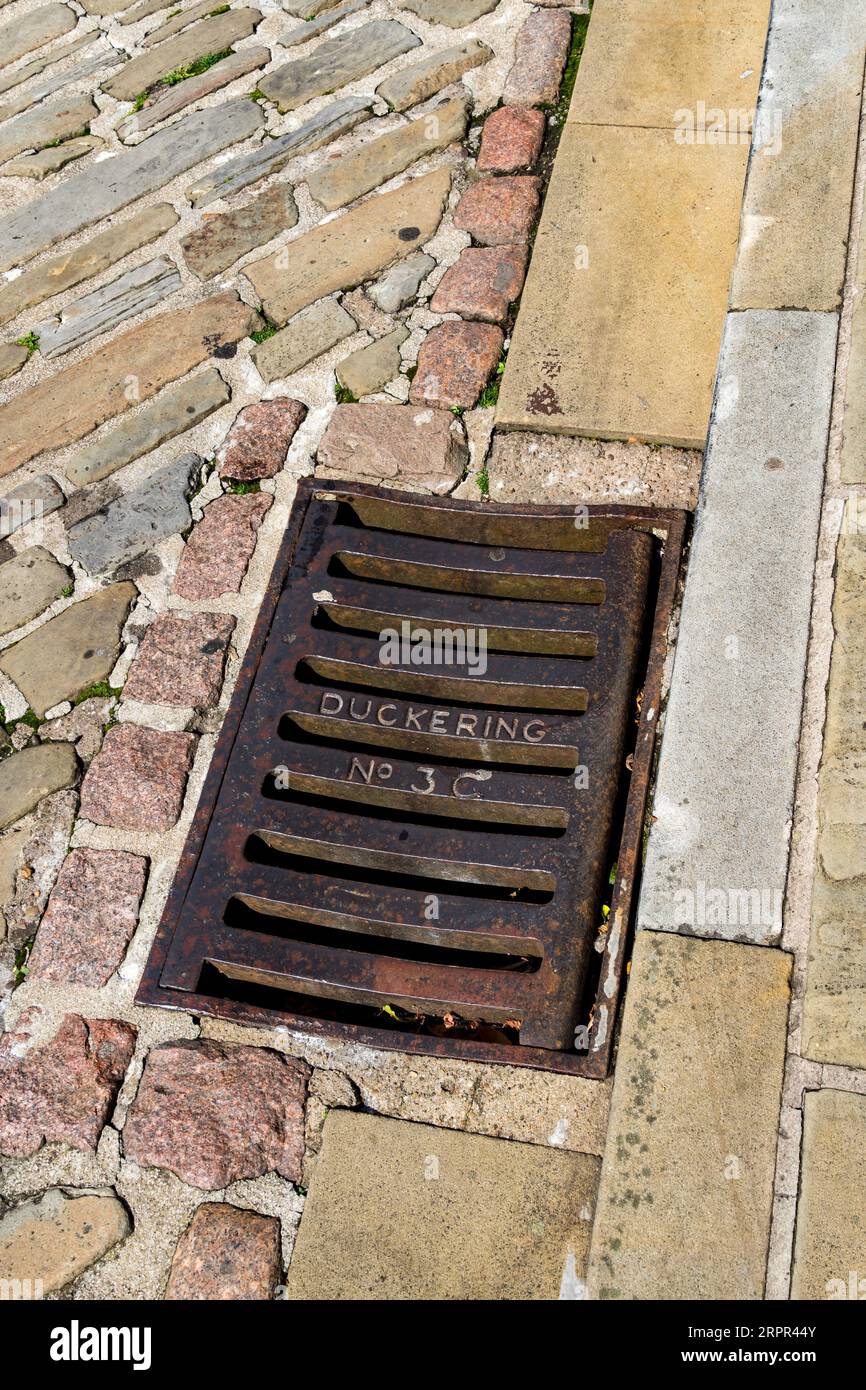Duckering No 3 C rainwater drain set in road gutter, Danesgate, Lincoln City, Lincolnshire, England, UK Stock Photo