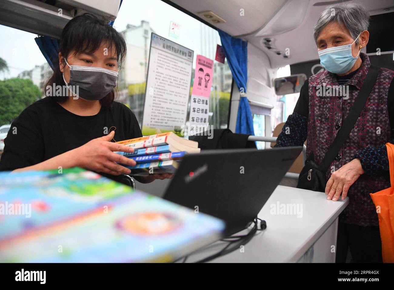 Changsa Library 200326 -- CHANGSHA, March 26, 2020 -- A staff member helps a resident ...