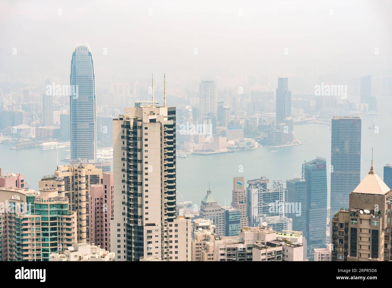 Hong Kong,March 26,2019:Panorama of skyscrapers, victoria harbor and hong kong bay taken from victoria peak park on hong kong island during a hazy day Stock Photo