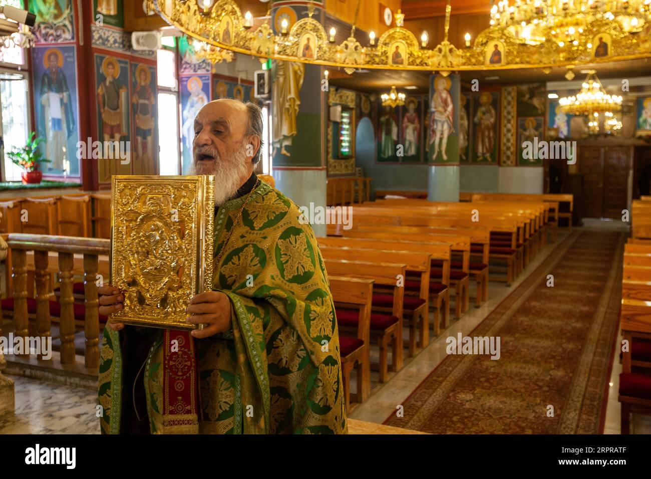 200330 -- BETHLEHEM, March 30, 2020 Xinhua -- A priest leads an empty Sunday Mass at an Orthodox church in Beit Sahour near the West Bank city of Bethlehem on March 29, 2020. For the first time ever, Raed al-Atrash, a 54-year-old Palestinian man from the West Bank city of Bethlehem, attended the Sunday Mass with his family through a live TV broadcast, as the churches are closed as part of the precautions against the spread of the novel coronavirus. TO GO WITH Feature: Christians in Palestine attend live prayers as churches close over coronavirus fears Photo by Luay Sababa/Xinhua MIDEAST-BETHLE Stock Photo