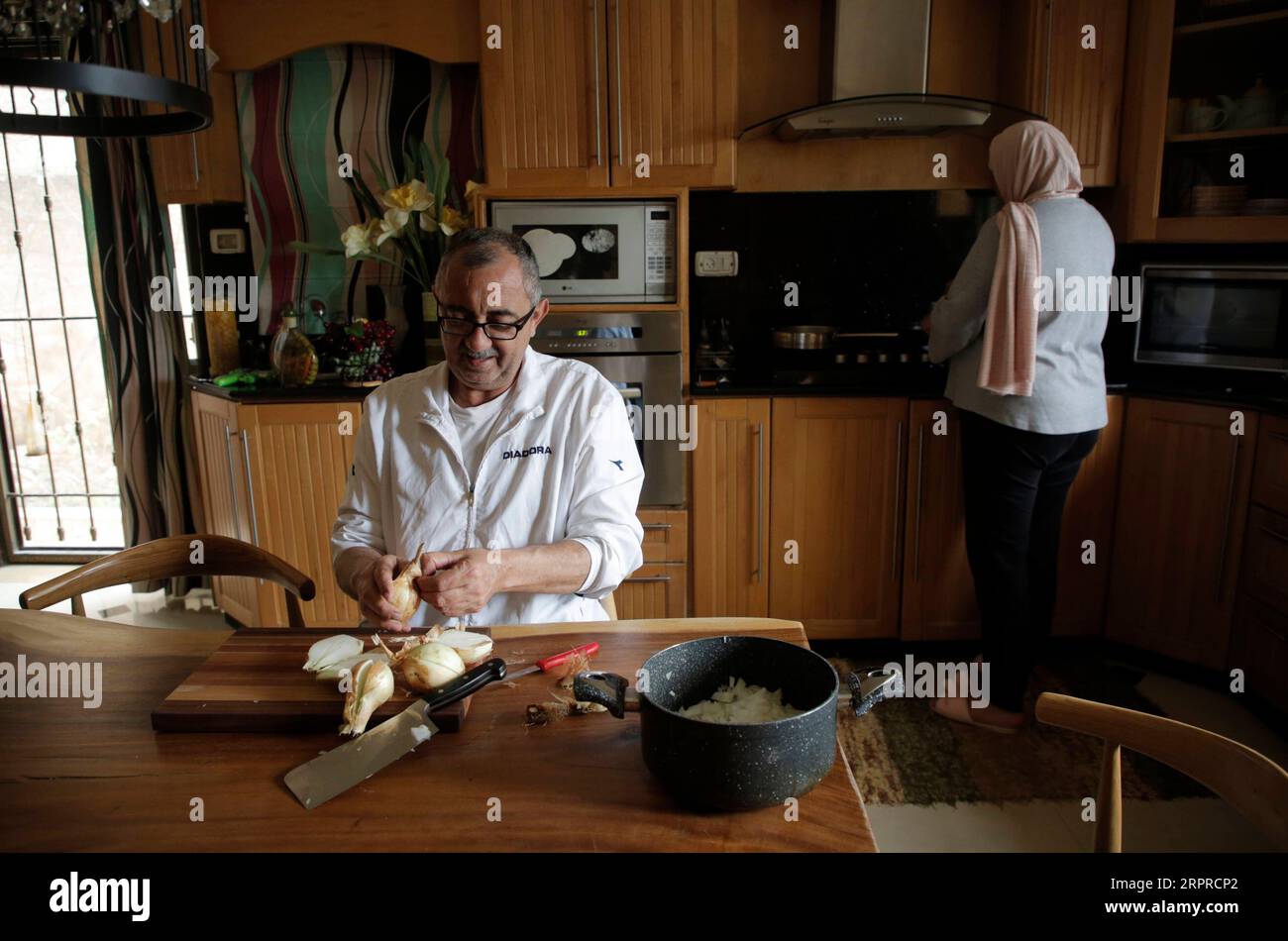 200401) -- NABLUS, April 1, 2020 (Xinhua) -- Palestinian chef Hasan Titi,  56, helps his wife Samar Titi in cooking and preparing homemade meal inside  their house kitchen in the West Bank