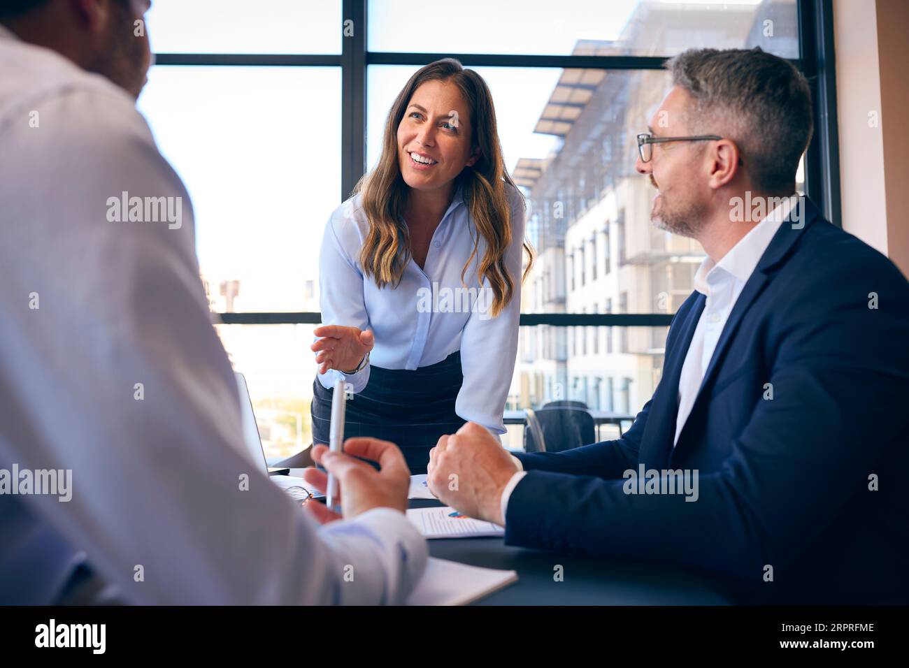 Team collaborating around table laptops hi-res stock photography and ...