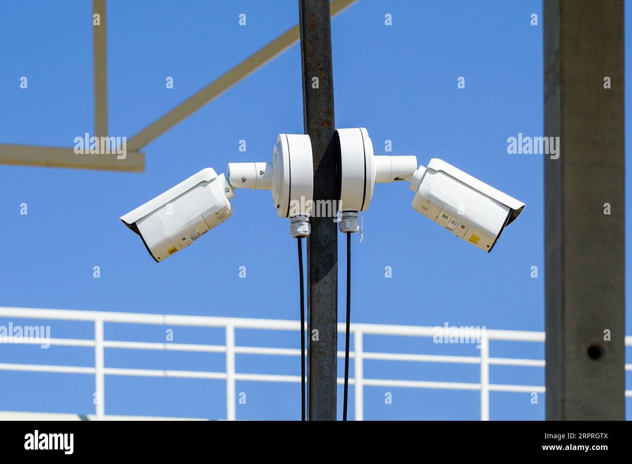 Metal pole with two outdoor security CCTV surveillance cameras in an