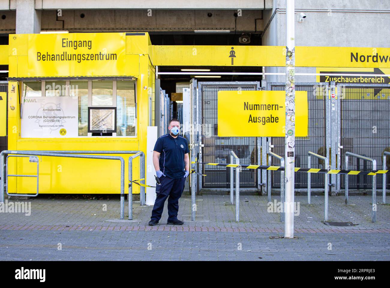 200405 -- DORTMUND, April 5, 2020 Xinhua -- A security member wearing a protective mask stands guard outside the COVID-19 testing center at Borussia Dortmund s stadium in Dortmund, Germany, April 4, 2020. Borussia Dortmund s stadium housed a COVID-19 testing center From Saturday. Rooms in the Westfalenstadion s north stand have been prepared to take in people suspected of suffering from COVID-19. It is hoped the center will relieve pressure on the medical facilities in the city of Dortmund. Photo by Joachim Bywaletz/Xinhua SPGERMANY-DORTMUND-STADIUM-COVID-19-TESTING CENTER PUBLICATIONxNOTxINxC Stock Photo