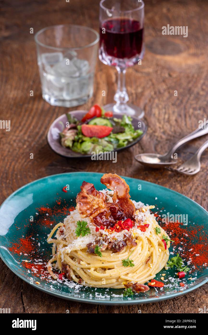 spaghetti carbonara with salad on wood Stock Photo