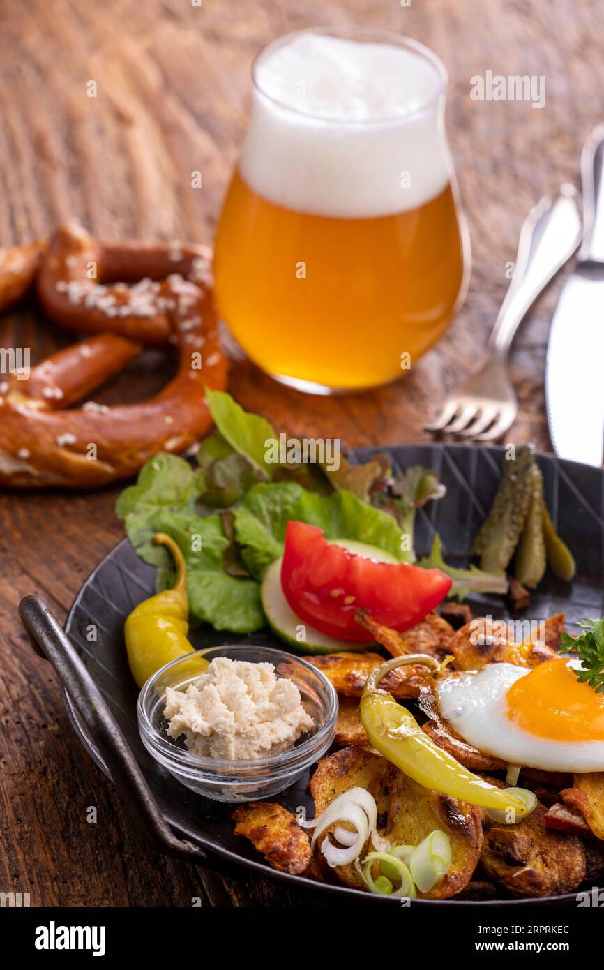 austrian potato dish on wood with beer Stock Photo