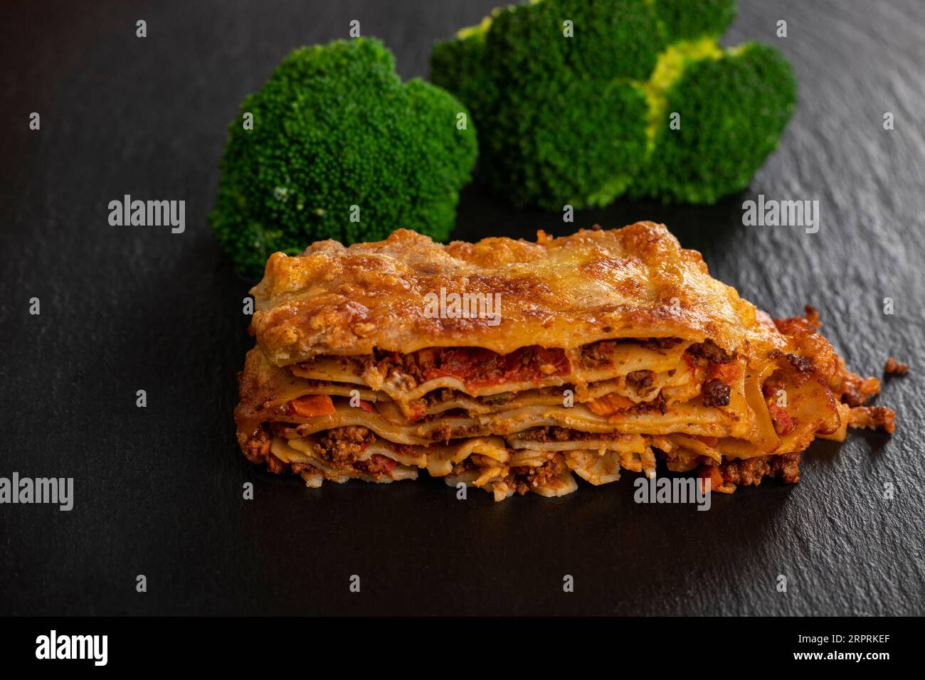 lasagna on slate with broccoli Stock Photo