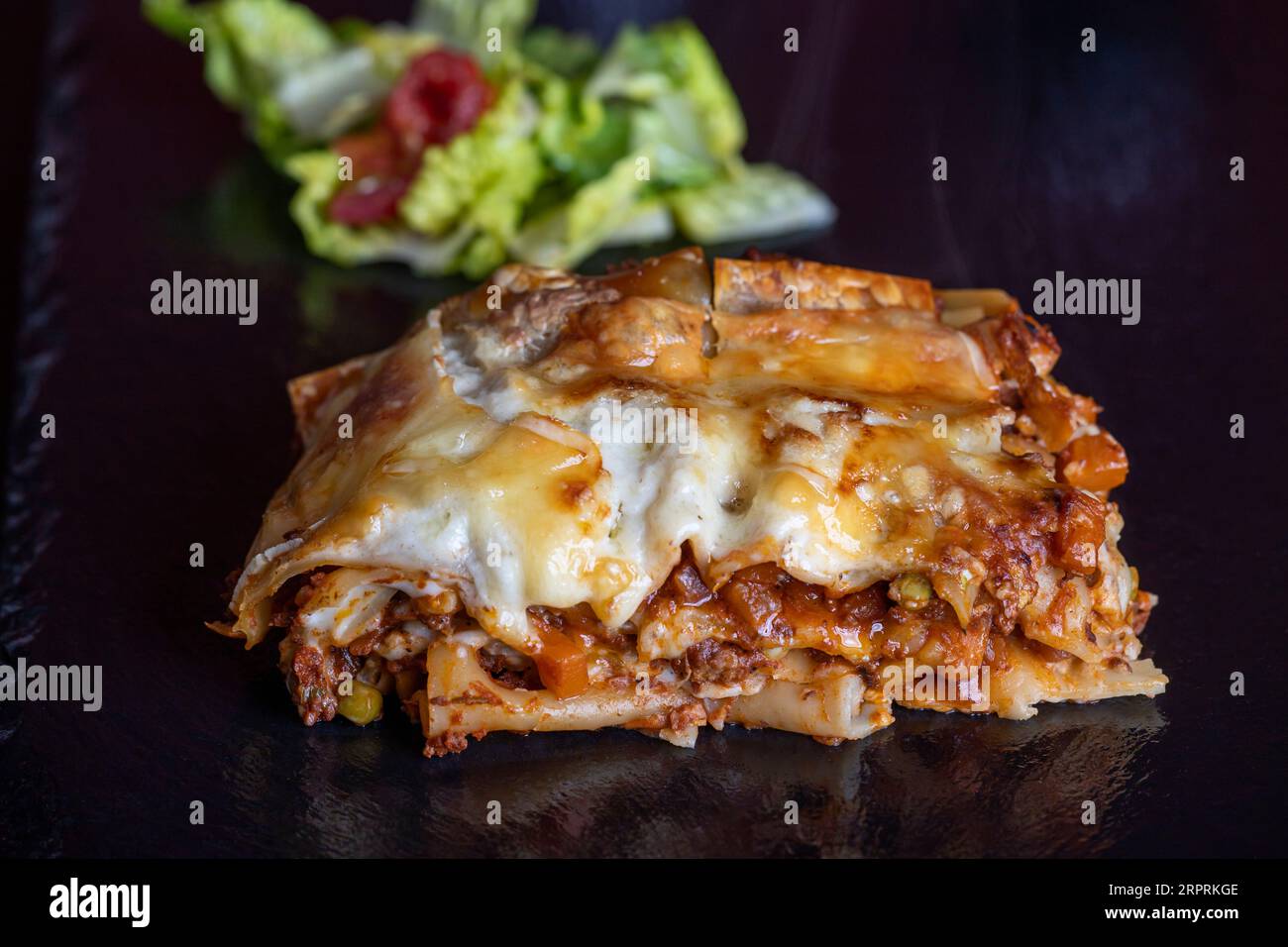 portion of lasagna on black slate Stock Photo