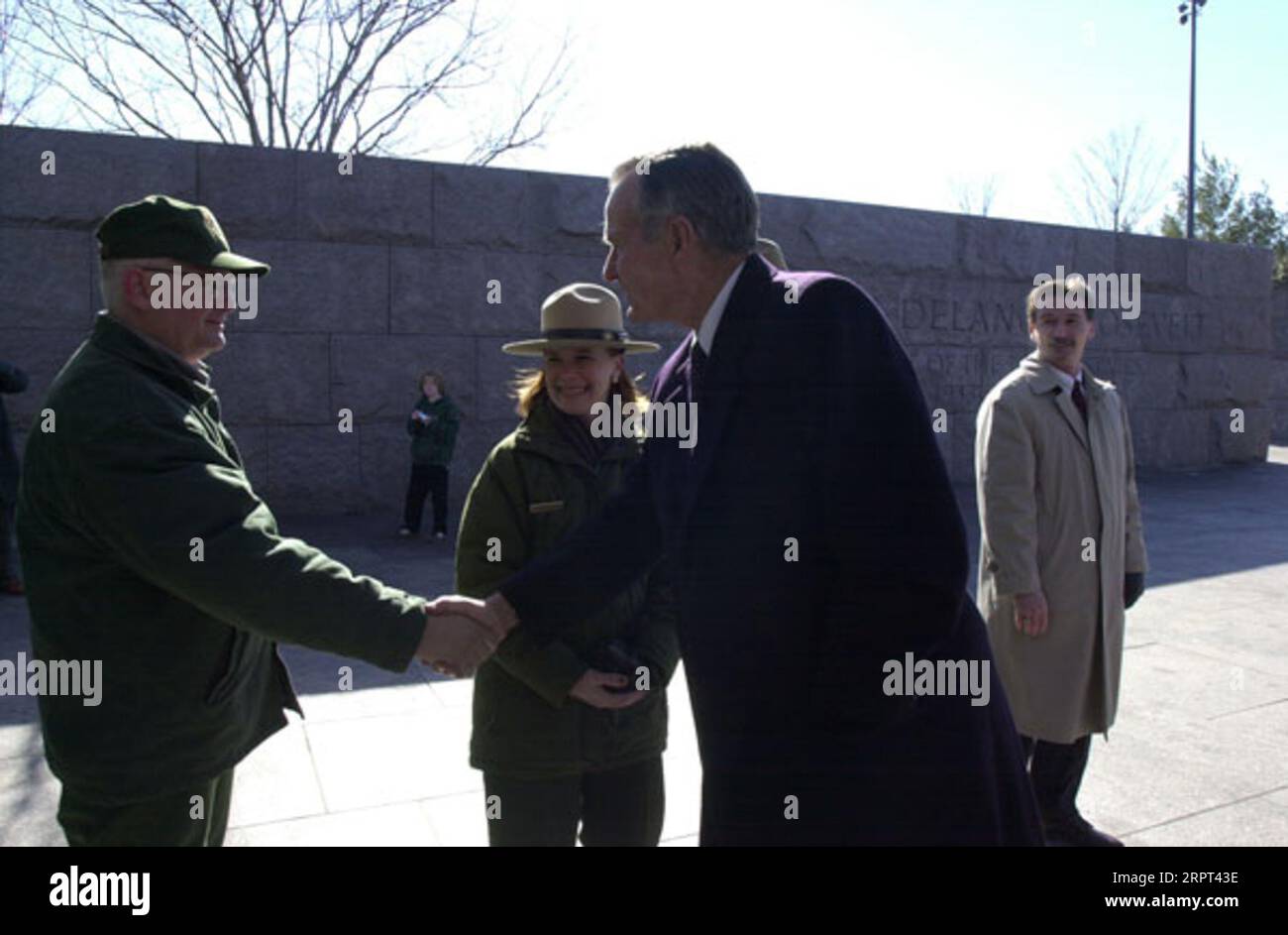 Former President George H.W. Bush, right, greeting well-wisher during visit to the Franklin Delano Roosevelt Memorial in Washington, D.C., for ceremony featuring the unveiling of the dedication panel for the statue of Franklin Delano Roosevelt in a wheelchair Stock Photo