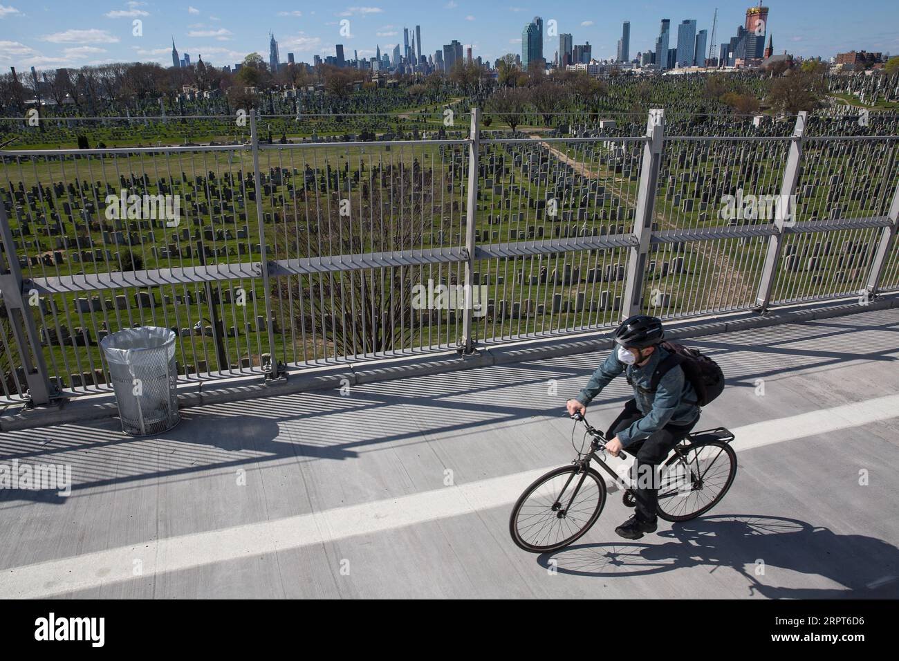 200411 -- NEW YORK, April 11, 2020 Xinhua -- A man rides a bike past the Calvary Cemetery, which is closed to visitors due to the coronavirus pandemic, in Queens of New York, the United States, April 11, 2020. The total number of deaths due to COVID-19 in the United States topped 20,000 Saturday afternoon, according to data compiled by the Center for Systems Science and Engineering CSSE at Johns Hopkins University. Photo by Michael Nagle/Xinhua U.S.-NEW YORK-COVID-19-DEATH TOLL PUBLICATIONxNOTxINxCHN Stock Photo