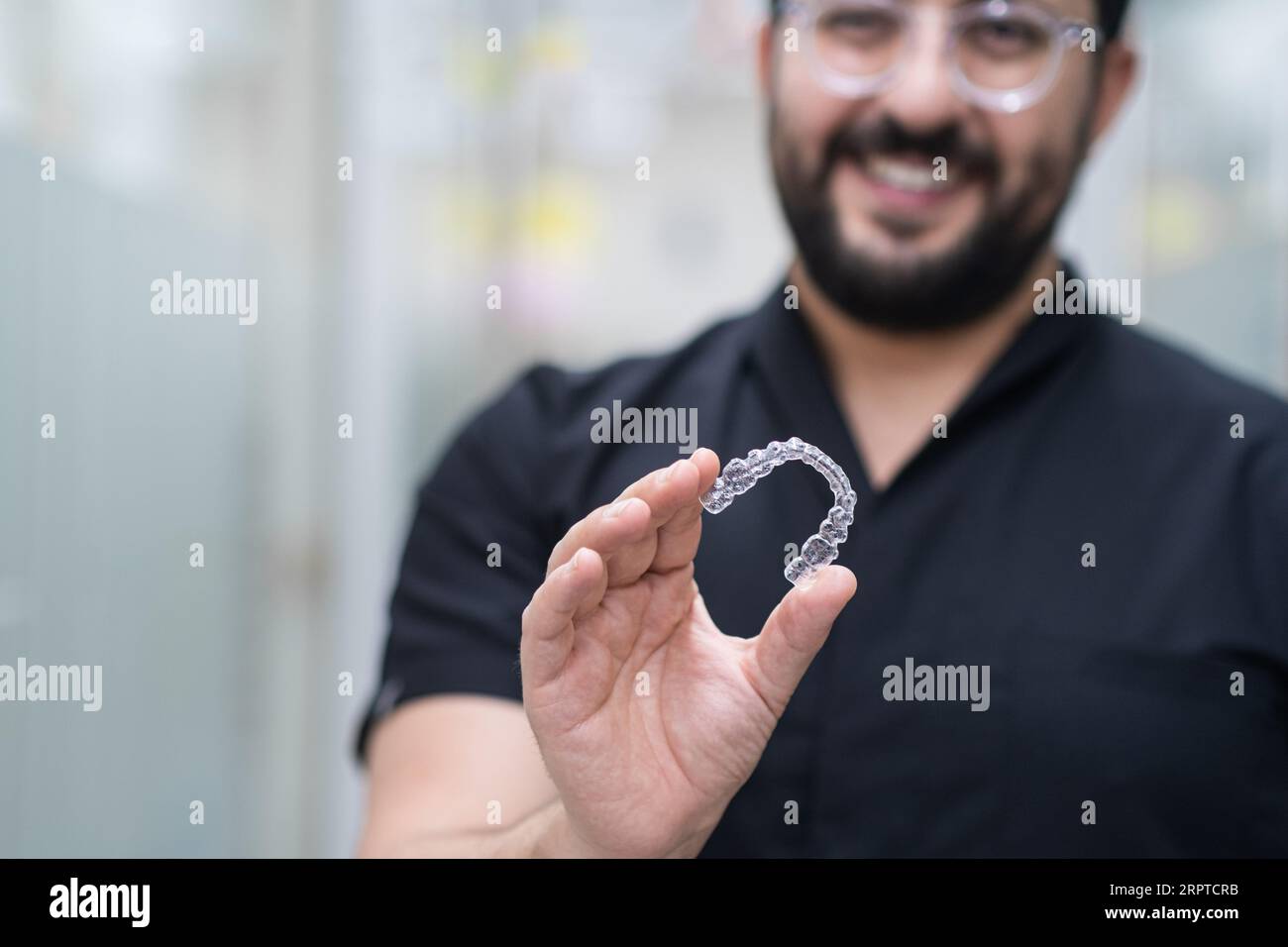 Positive dentist demonstrating clear aligners used for teeth ...
