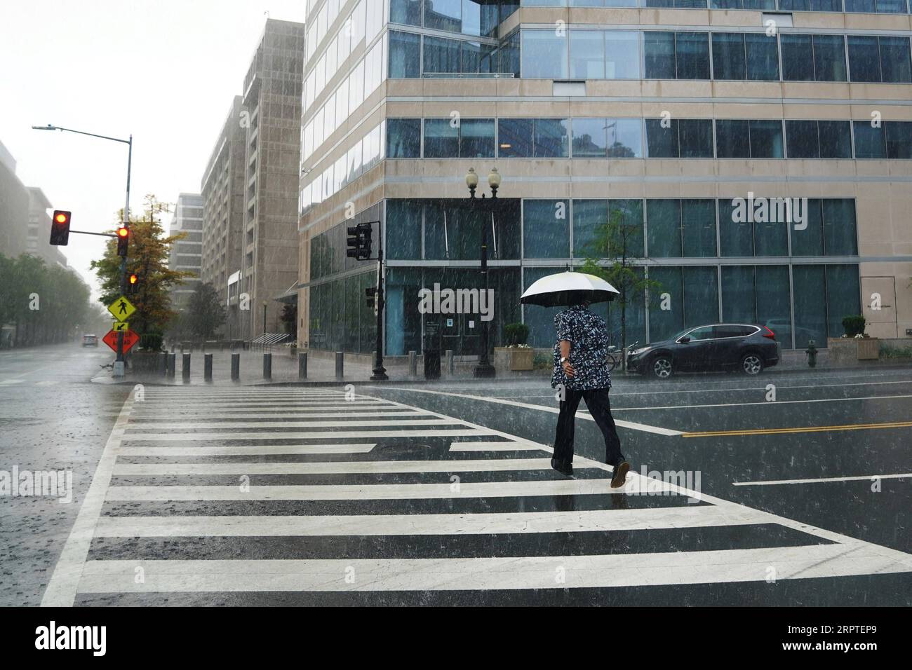 200415 -- BEIJING, April 15, 2020 -- A man crosses a road in the rain near the International Monetary Fund IMF Headquarters in Washington D.C., the United States, April 13, 2020. The global economy is on track to contract sharply by 3 percent in 2020 as a result of the COVID-19 pandemic, much worse than during the 2008-09 financial crisis, according to the International Monetary Fund IMF s World Economic Outlook released Tuesday.  XINHUA PHOTOS OF THE DAY LiuxJie PUBLICATIONxNOTxINxCHN Stock Photo