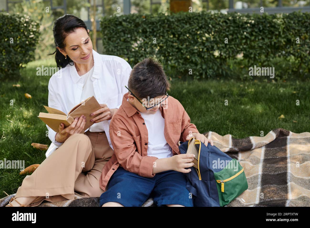 Take Off Book boy with down syndrome taking off book from school backpack near happy ...
