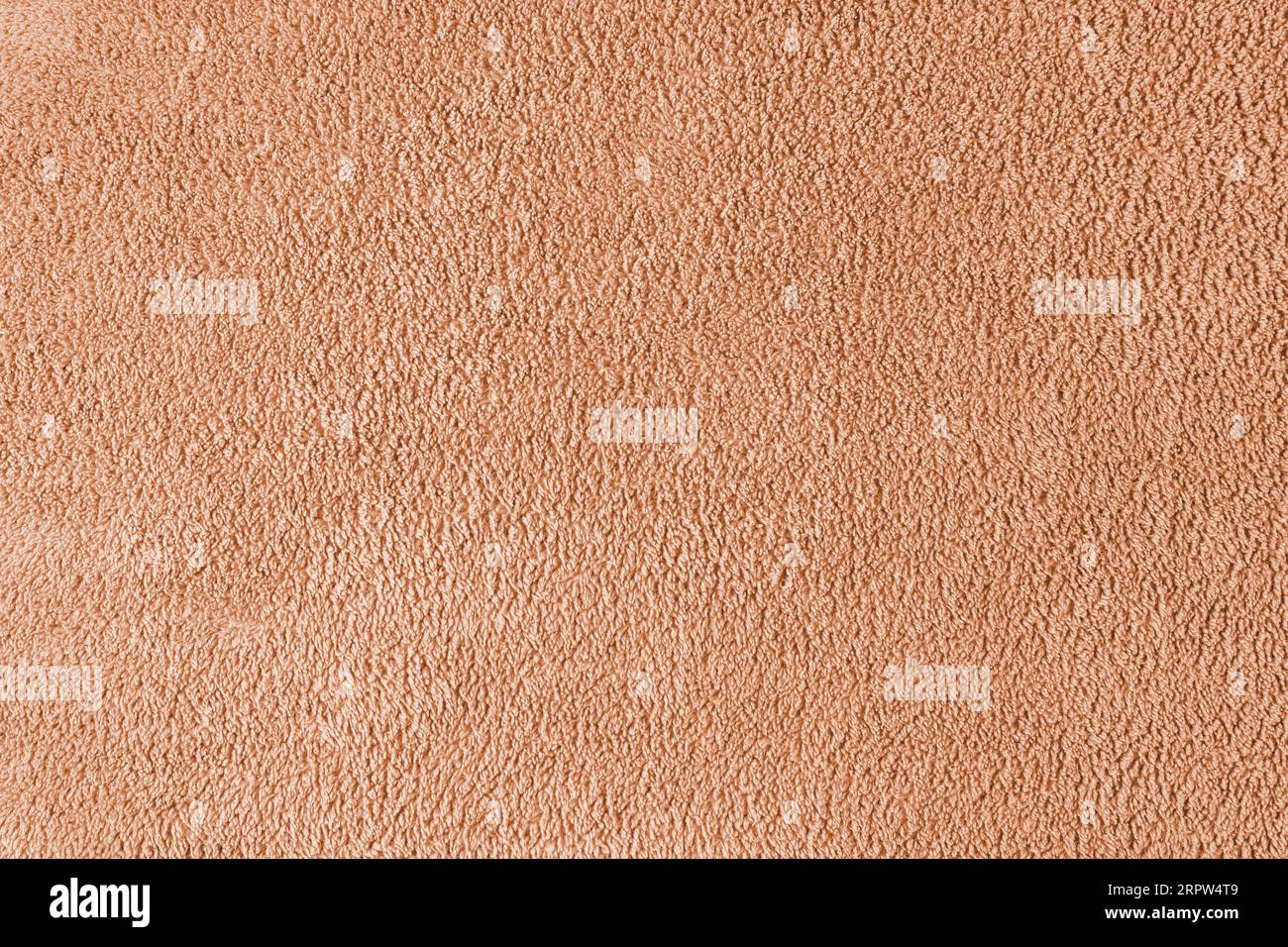 Terry cloth, orange towel texture background. Soft fluffy textile bath or beach towel material. Top view, close up. Stock Photo
