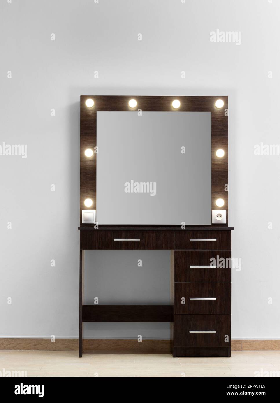 Dark makeup dressing table with a large mirror and lamps against a