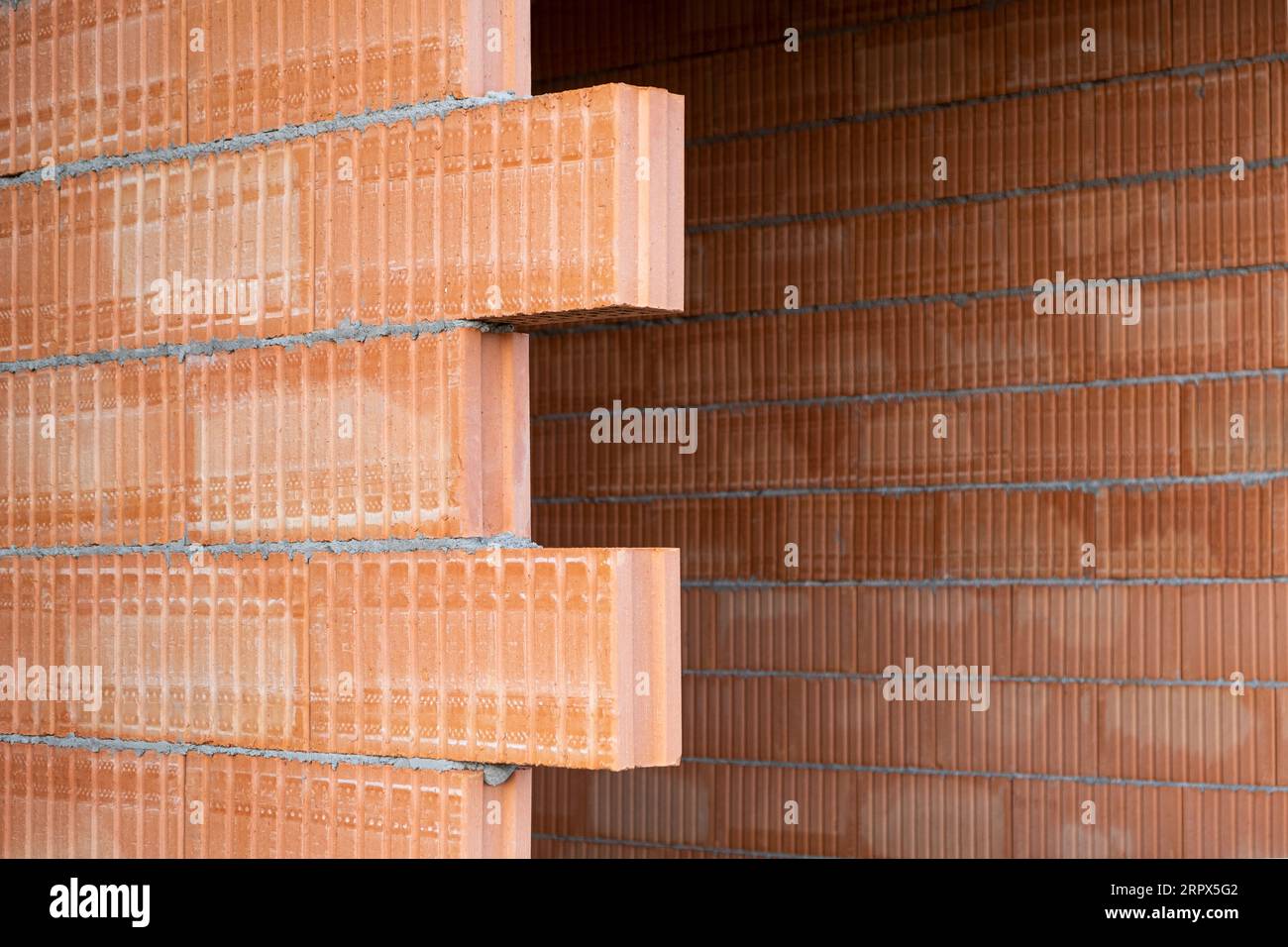 Red clay Ceramic Thermo Bricks construction material. Construction site with walls. Stock Photo