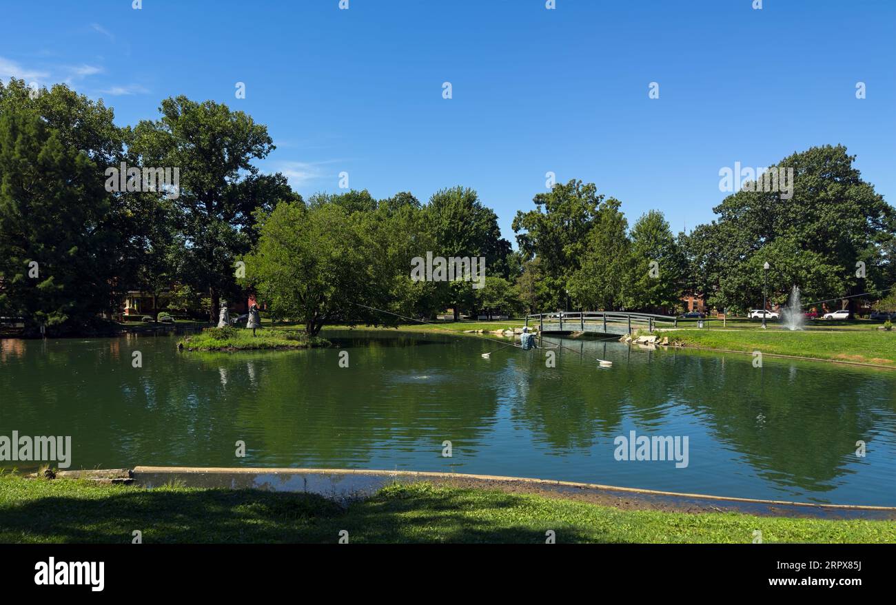 Sculptures on Schiller Pond--on a small island and suspended above the water--and a fountain add points of interest to Schiller Park in German Village. Stock Photo