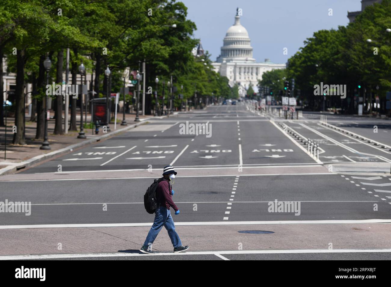 200516 -- WASHINGTON D.C., May 16, 2020 -- A man wearing a face mask crosses a street near the U.S. Capitol building in Washington D.C., the United States, May 15, 2020. U.S. House of Representatives on Friday passed a 3-trillion-U.S.-dollar coronavirus relief package, which was proposed by Democrats but not likely to gain approval from Republican-held Senate.  U.S.-WASHINGTON D.C.-COVID-19-RELIEF PACKAGE LiuxJie PUBLICATIONxNOTxINxCHN Stock Photo