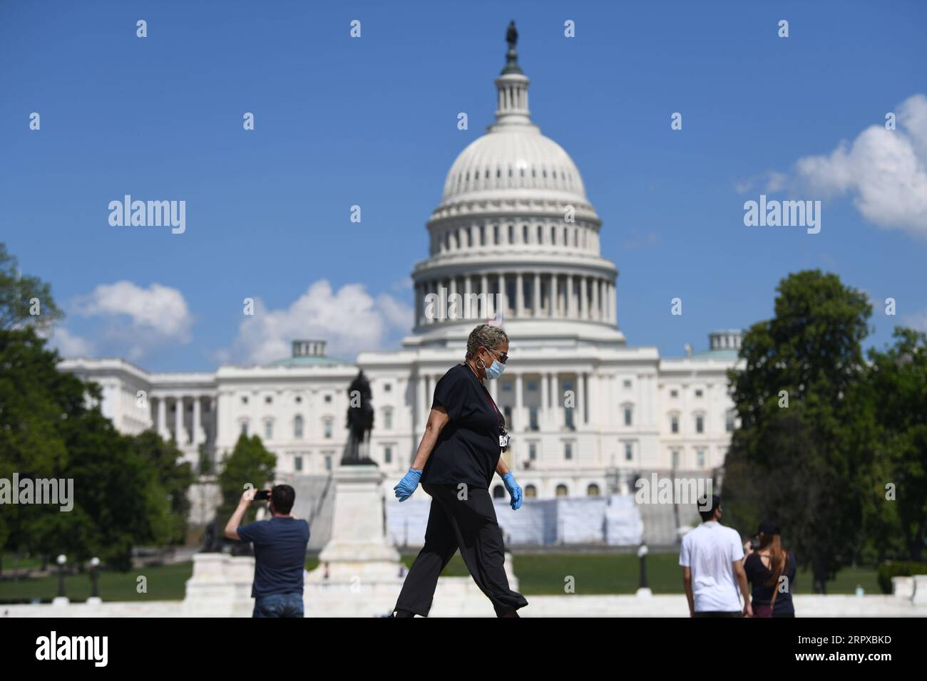 200516 -- WASHINGTON D.C., May 16, 2020 -- A woman wearing a face mask walks past the U.S. Capitol building in Washington D.C., the United States, May 15, 2020. U.S. House of Representatives on Friday passed a 3-trillion-U.S.-dollar coronavirus relief package, which was proposed by Democrats but not likely to gain approval from Republican-held Senate.  U.S.-WASHINGTON D.C.-COVID-19-RELIEF PACKAGE LiuxJie PUBLICATIONxNOTxINxCHN Stock Photo