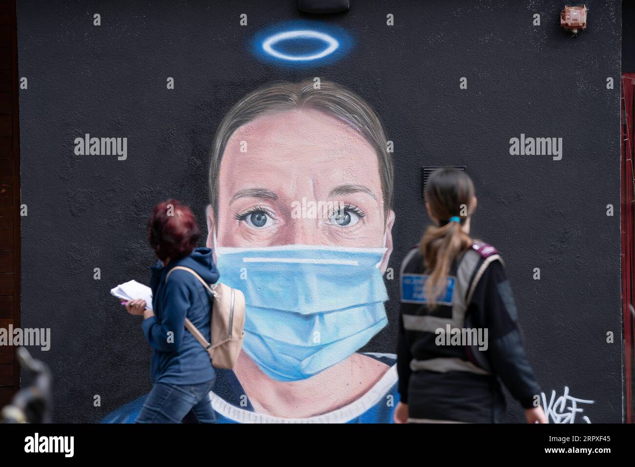 200520 -- MANCHESTER, May 20, 2020 -- People walk past a mural by a street artist depicting Debra Williams, an operating department practitioner at Manchester Royal Infirmary, in Manchester, Britain, May 19, 2020. Photo by /Xinhua BRITAIN-MANCHESTER-COVID-19-MURAL JonxSuper PUBLICATIONxNOTxINxCHN Stock Photo