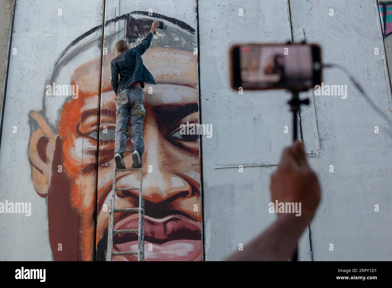 200610 -- BETHLEHEM, June 10, 2020 Xinhua -- Palestinian artist Taqi Spateen paints a mural of George Floyd on the Israeli separation wall in the West Bank city of Bethlehem, June 9, 2020. Photo by Luay Sababa/Xinhua MIDEAST-BETHLEHEM-GEORGE FLOYD-MURAL PUBLICATIONxNOTxINxCHN Stock Photo