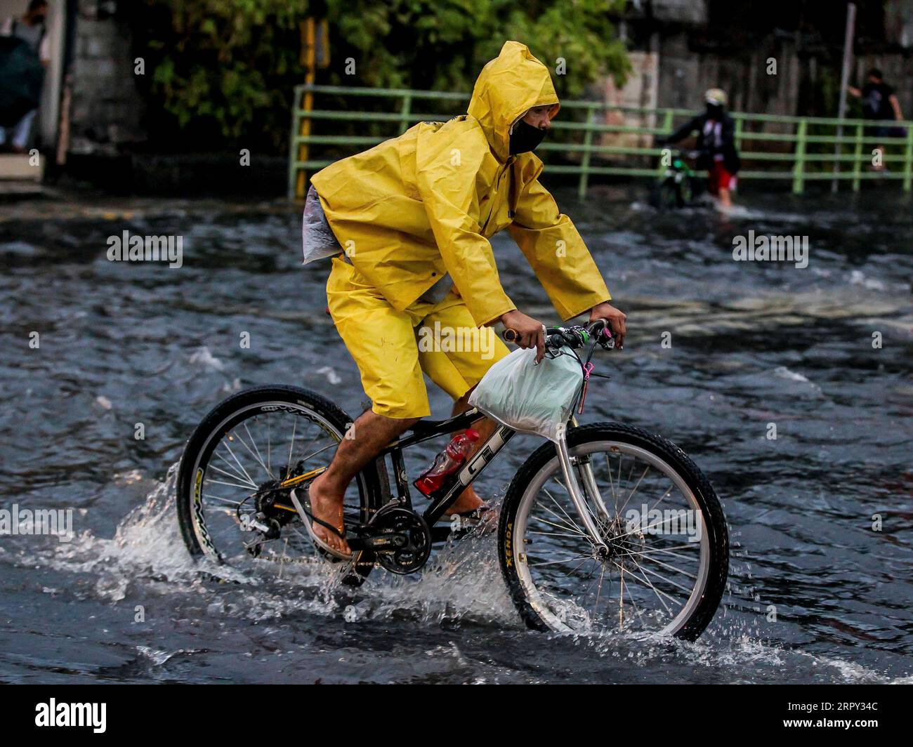 200612 -- BEIJING, June 12, 2020 -- A man rides a bicycle through a flooded area caused by the heavy rain from the tropical depression locally named Butchoy in Manila, the Philippines, on June 11, 2020.  XINHUA PHOTOS OF THE DAY ROUELLExUMALI PUBLICATIONxNOTxINxCHN Stock Photo