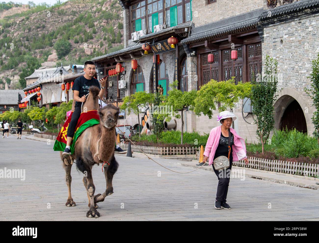 200612 -- LINXIAN, June 12, 2020 -- A tourist rides a camel at the Qikou ancient town in Linxian County of Lyuliang, north China s Shanxi Province, June 9, 2020.  CHINA-SHANXI-LINXIAN-ANCIENT TOWN-VIEW CN YangxChenguang PUBLICATIONxNOTxINxCHN Stock Photo
