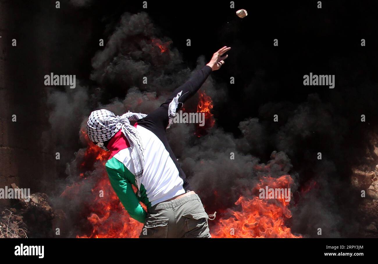 200612 -- NABLUS, June 12, 2020 Xinhua -- A Palestinian protester hurls stones at Israeli soldiers during clashes after a protest against the expansion of Jewish settlements in Kufr Qadoom village near the West Bank city of Nablus, June 12, 2020. Photo by Nidal Eshtayeh/Xinhua MIDEAST-NABLUS-CLASHES PUBLICATIONxNOTxINxCHN Stock Photo