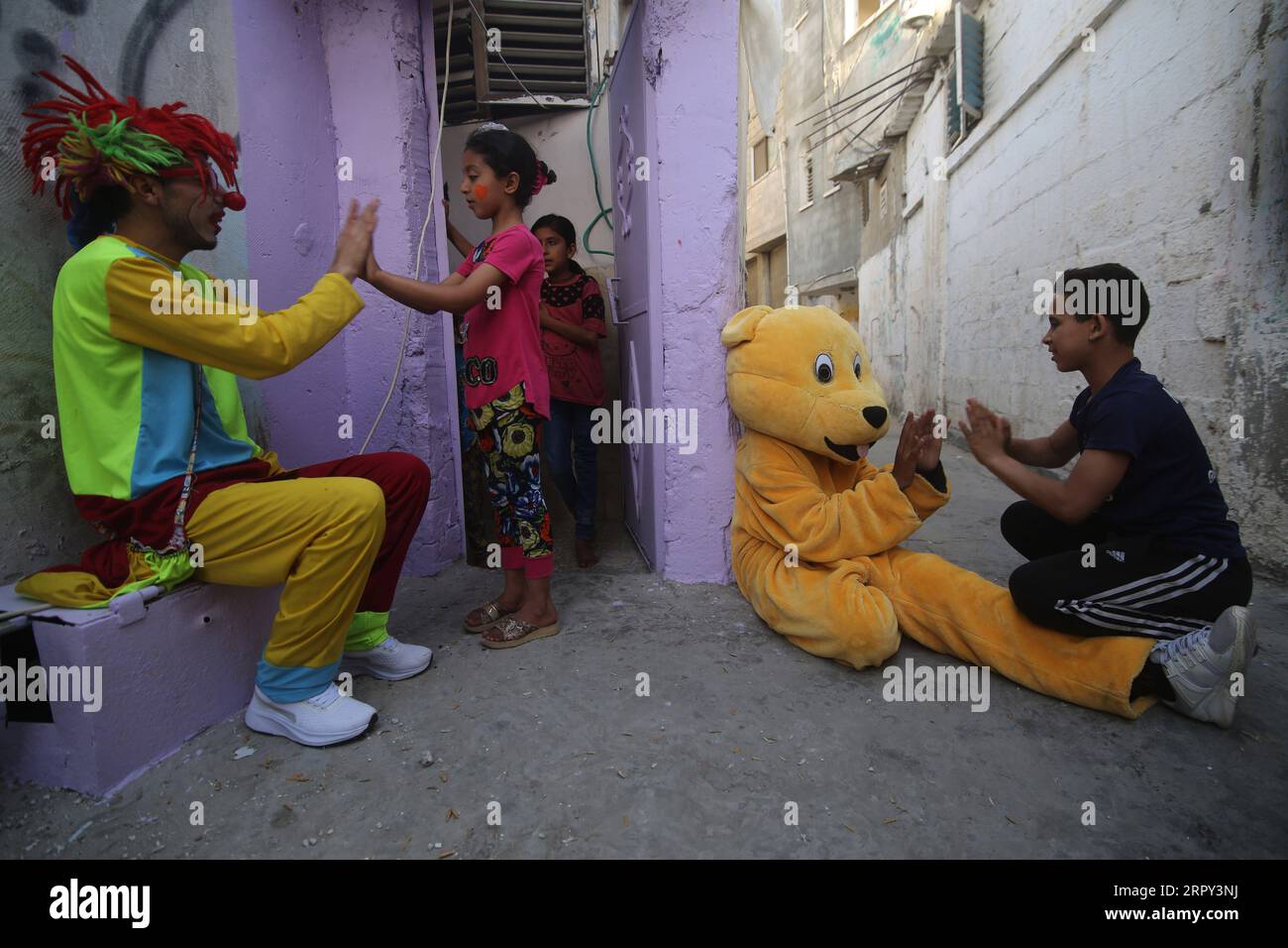 200612 -- GAZA, June 12, 2020 Xinhua -- Palestinian volunteers dressed as a clown and a bear play with refugee children in an effort to lift their spirits in the southern Gaza Strip city of Rafah, on June 12, 2020. Photo by Khaled Omar/Xinhua MIDEAST-GAZA-RAFAH-VOLUNTEERS-REFUGEE CHILDREN PUBLICATIONxNOTxINxCHN Stock Photo
