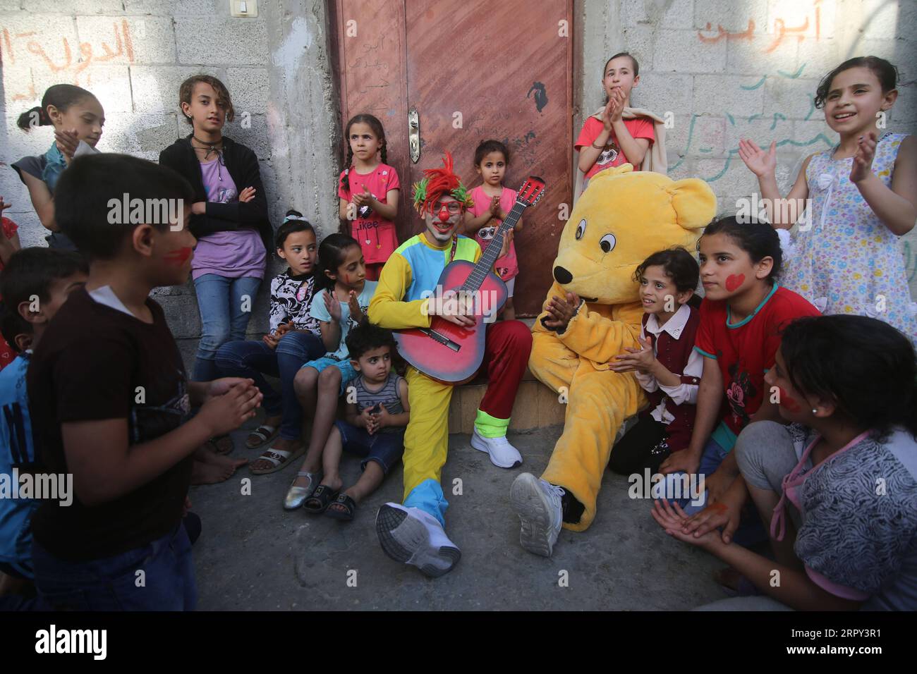 200612 -- GAZA, June 12, 2020 Xinhua -- Palestinian volunteers dressed as a clown and a bear perform for refugee children in an effort to lift their spirits in the southern Gaza Strip city of Rafah, on June 12, 2020. Photo by Khaled Omar/Xinhua MIDEAST-GAZA-RAFAH-VOLUNTEERS-REFUGEE CHILDREN PUBLICATIONxNOTxINxCHN Stock Photo