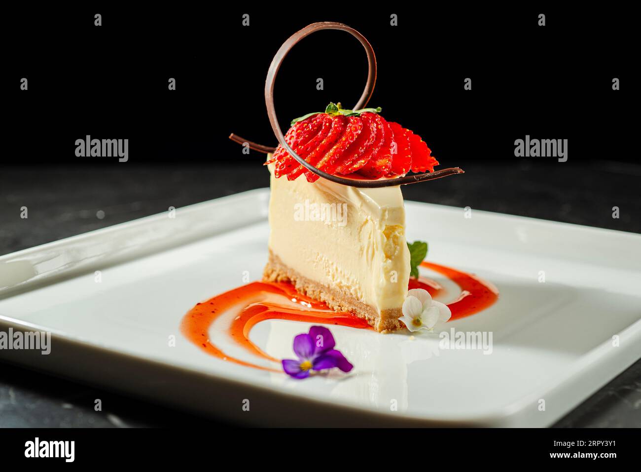 Plated dessert with a rich cheesecake and a creamy Vanilla Panna Cotta