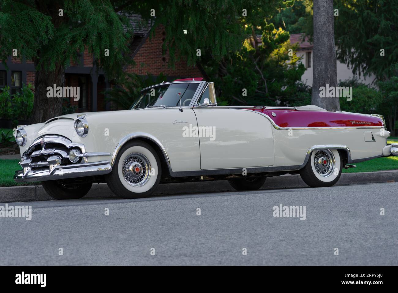 Classic Packard Caribbean convertible car shown parked in a residential area. Stock Photo
