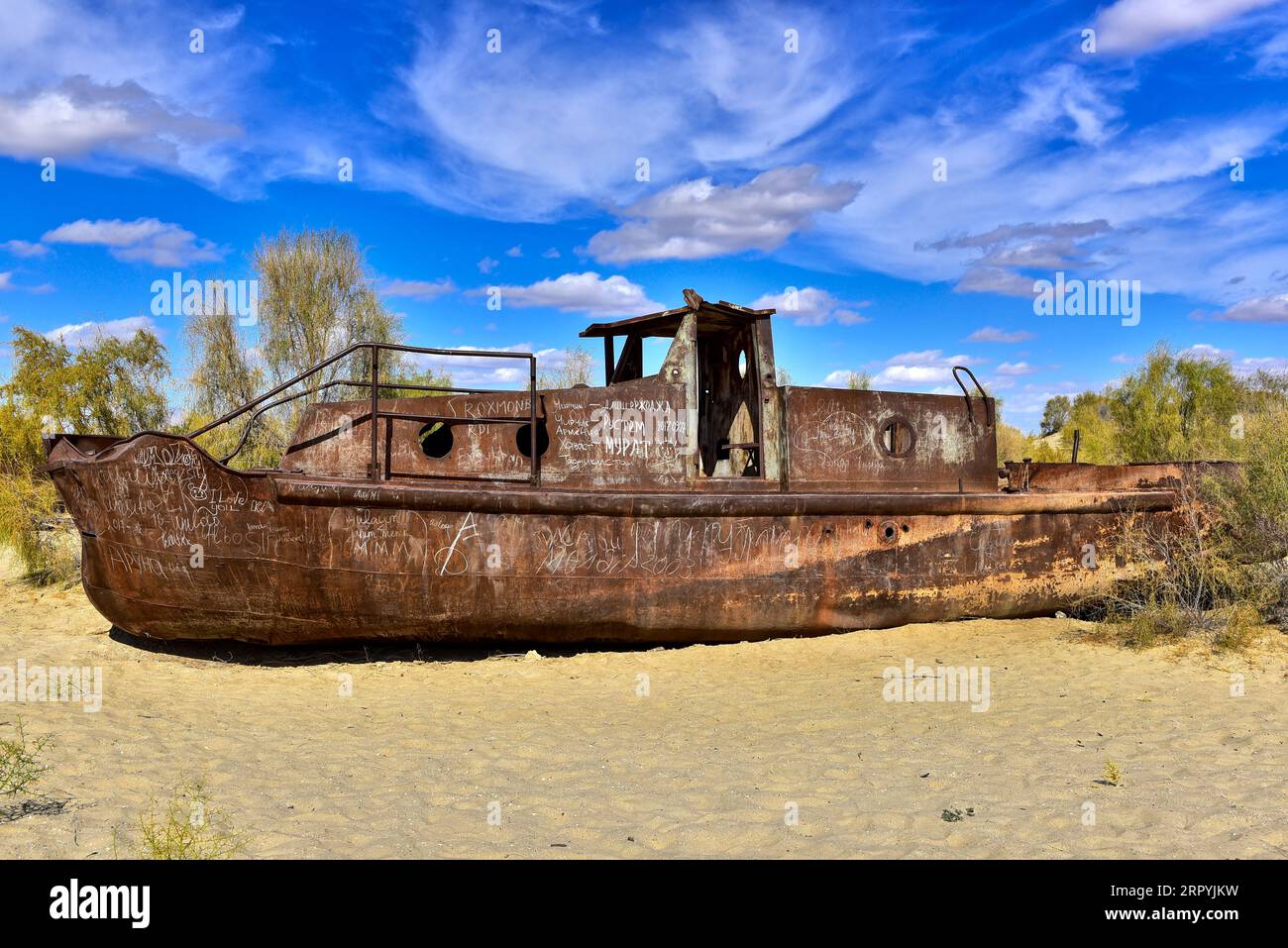 Rusting boat lying on the desert that used to be Aral Sea, the fourth largest lake in the world up until the 1960s. Muynak, Uzbekistan Stock Photo