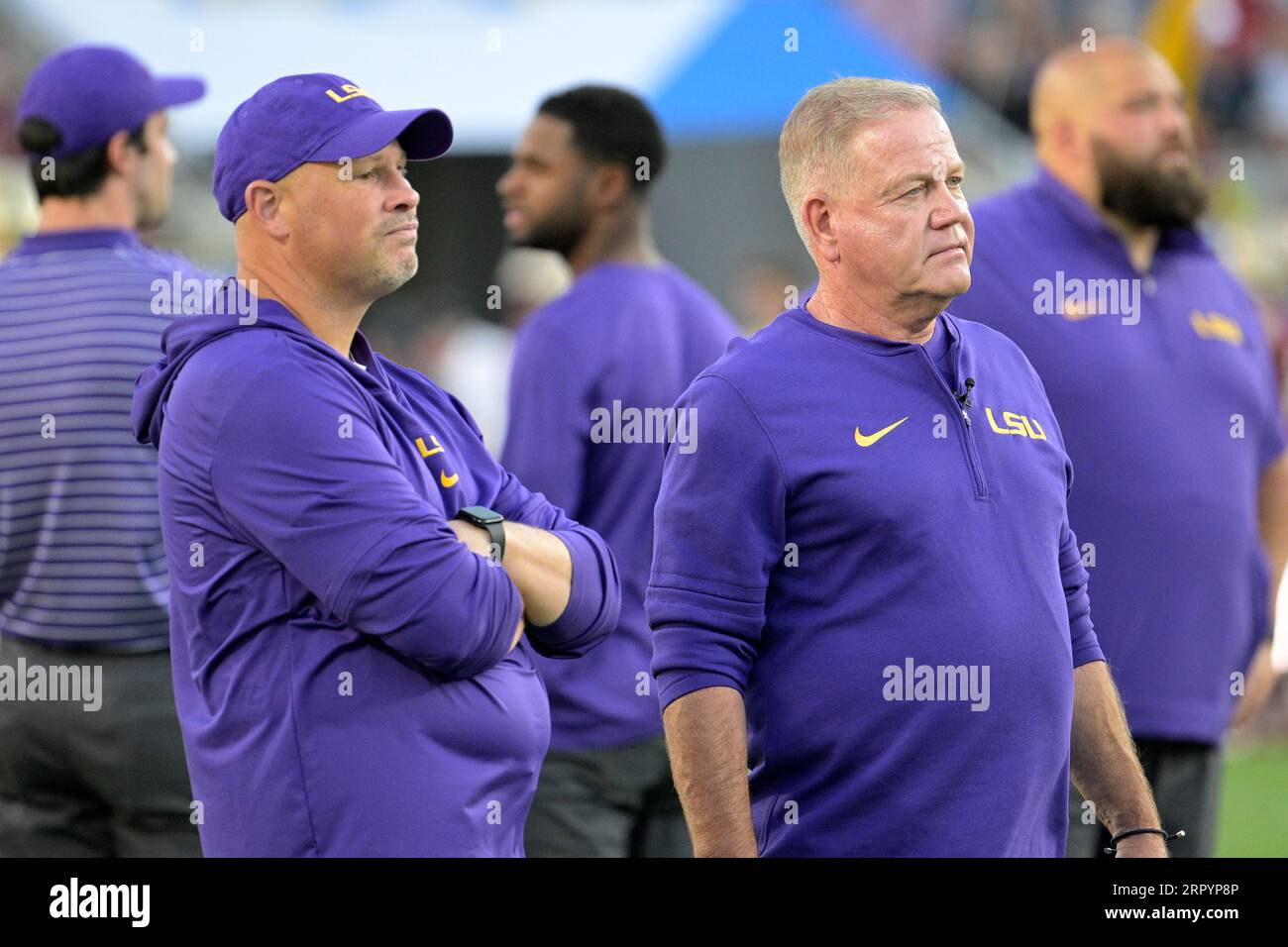 LSU head coach Brian Kelly and defensive coordinator Matt House, left, chat  on the field while watching players warmup up before an NCAA college  football game against Florida State, Sunday, Sept. 3,