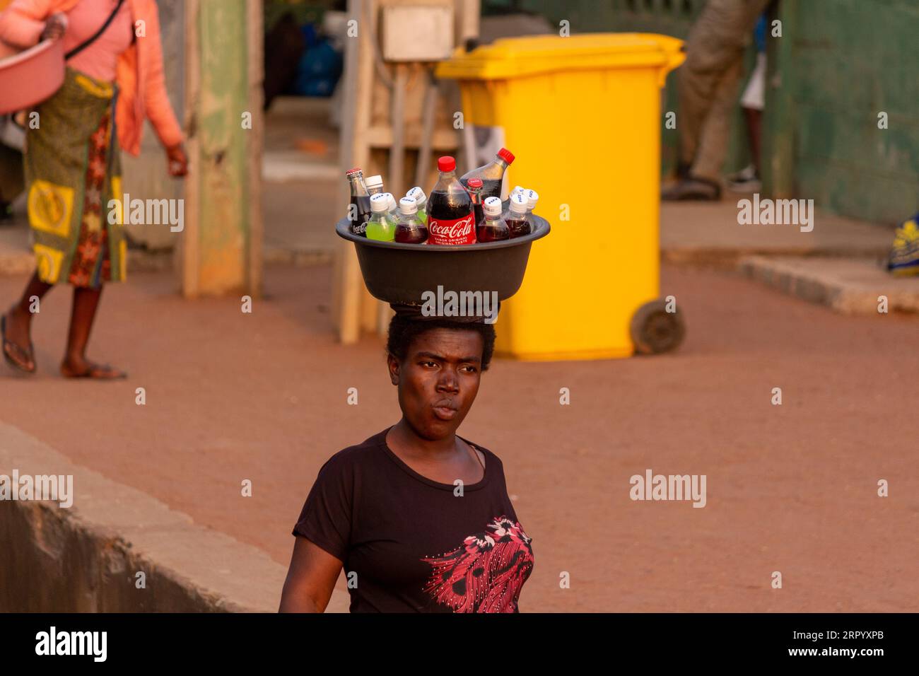 African Woman Carrying Packaged Beverages on Her Head Stock Photo