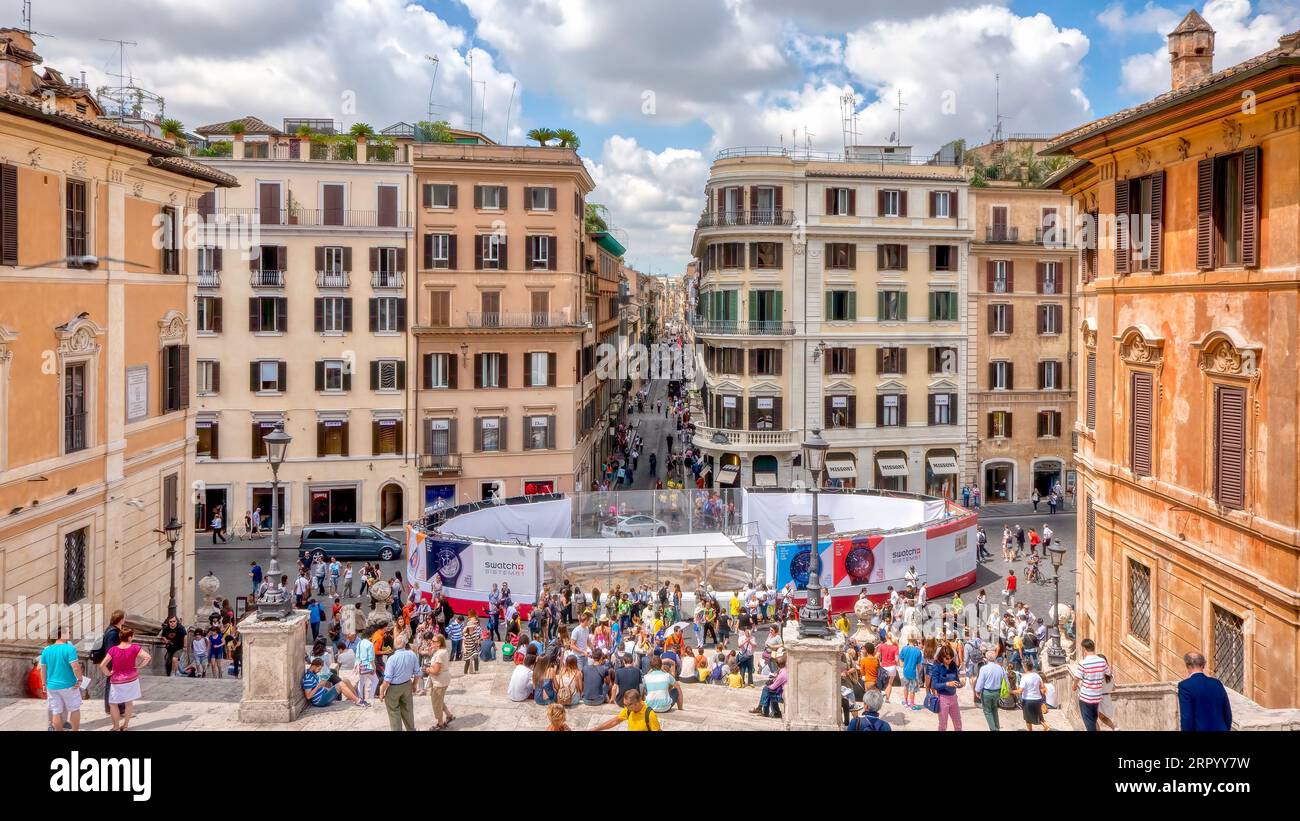 Rome, Italy - June 18, 2014: Tourists gathered near the Fontana della Barcaccia, while fenced off for restoration, at the bottom of the Spanish Steps. Stock Photo